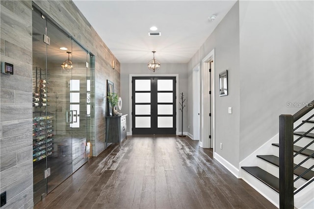 foyer with a chandelier, french doors, dark hardwood / wood-style floors, and elevator