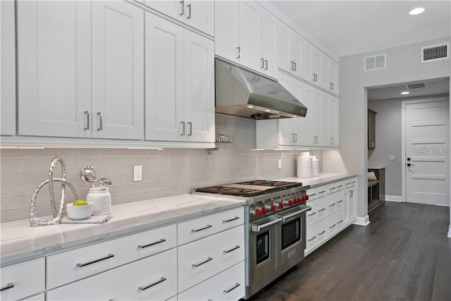 kitchen with white cabinets, dark hardwood / wood-style floors, double oven range, and light stone counters