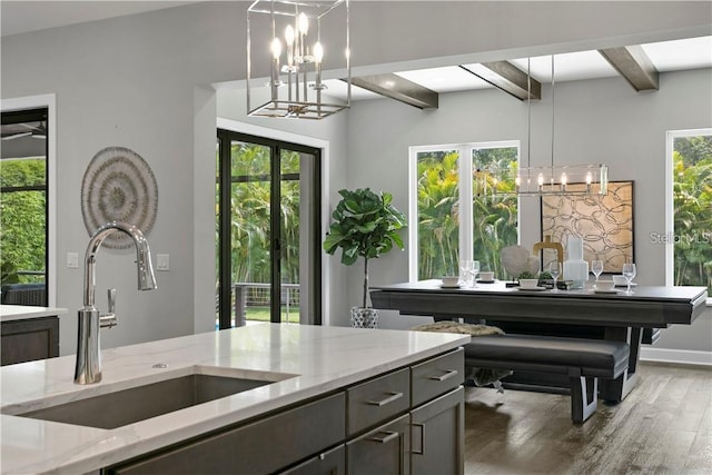 misc room featuring beam ceiling, sink, french doors, dark wood-type flooring, and an inviting chandelier