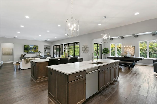 kitchen featuring pendant lighting, a kitchen island with sink, sink, stainless steel dishwasher, and dark hardwood / wood-style floors