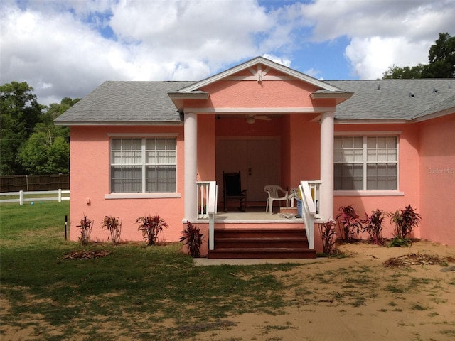 back of house featuring a lawn and a deck