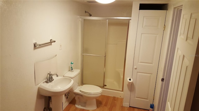 bathroom with toilet, hardwood / wood-style floors, and an enclosed shower