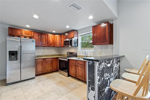 kitchen with tasteful backsplash, sink, stainless steel appliances, and kitchen peninsula