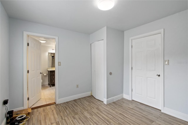 unfurnished bedroom with light hardwood / wood-style floors and a closet