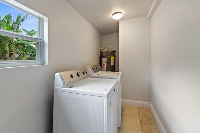 washroom featuring independent washer and dryer, electric water heater, and light tile patterned floors