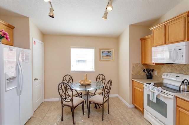 kitchen with light tile patterned flooring, white appliances, a textured ceiling, and backsplash