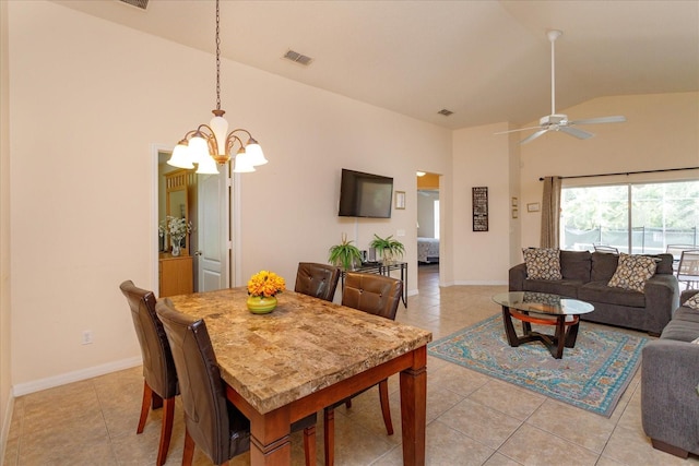 tiled dining area with ceiling fan with notable chandelier and high vaulted ceiling