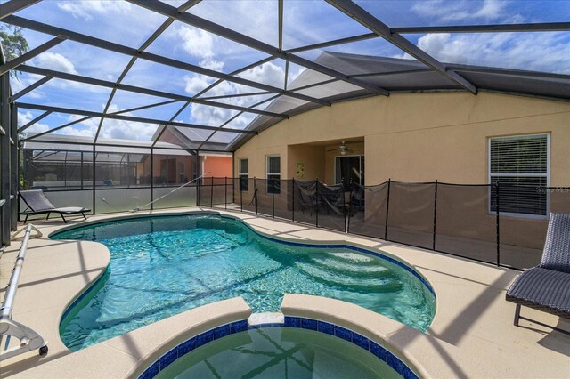 view of swimming pool featuring ceiling fan, a patio, glass enclosure, and an in ground hot tub