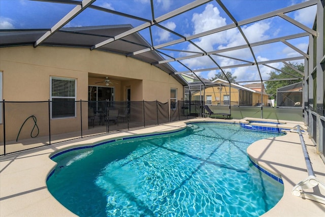 view of pool with an in ground hot tub, a patio, and glass enclosure