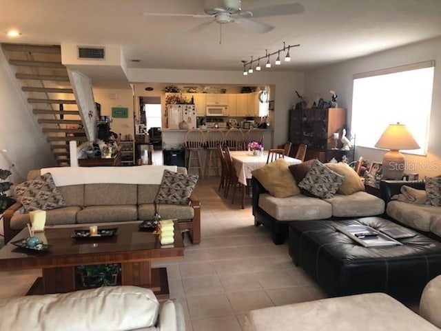 living room with light tile floors, rail lighting, and ceiling fan