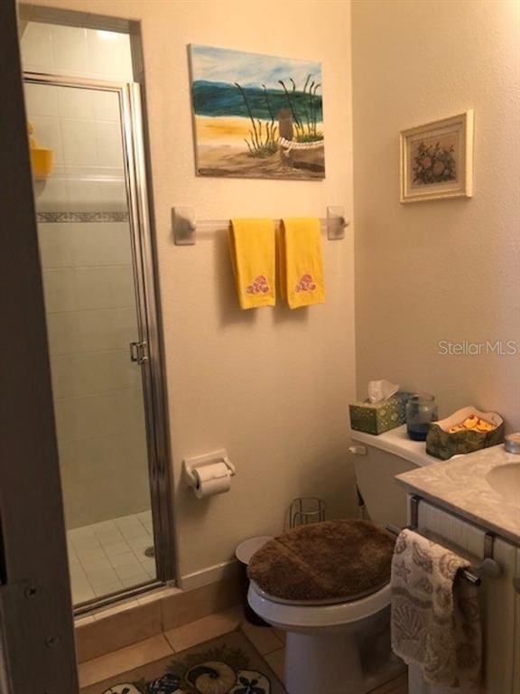 bathroom featuring walk in shower, toilet, tile floors, and vanity