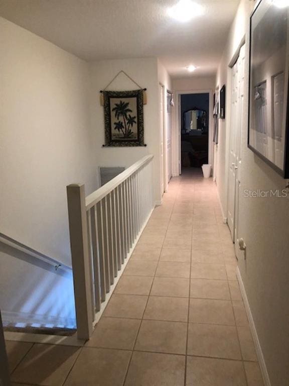 hall featuring light tile flooring