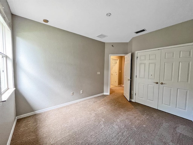 unfurnished bedroom with dark carpet and multiple windows