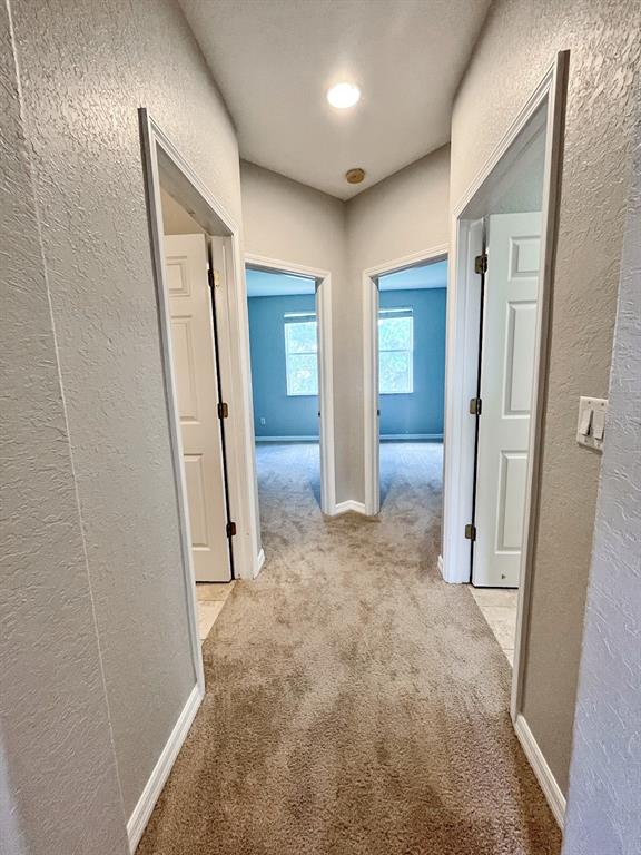 corridor featuring light colored carpet