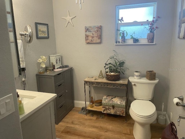 bathroom featuring wood-type flooring, vanity, and toilet