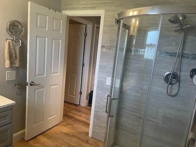 bathroom featuring an enclosed shower, vanity, and hardwood / wood-style floors