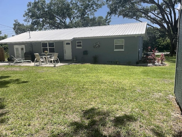 rear view of house with a patio and a yard