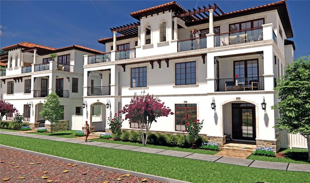 view of front of property featuring a balcony and a front yard