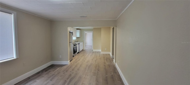 hall featuring light wood-type flooring and ornamental molding