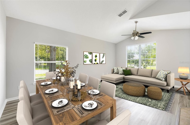 living room featuring ceiling fan, plenty of natural light, wood-type flooring, and vaulted ceiling