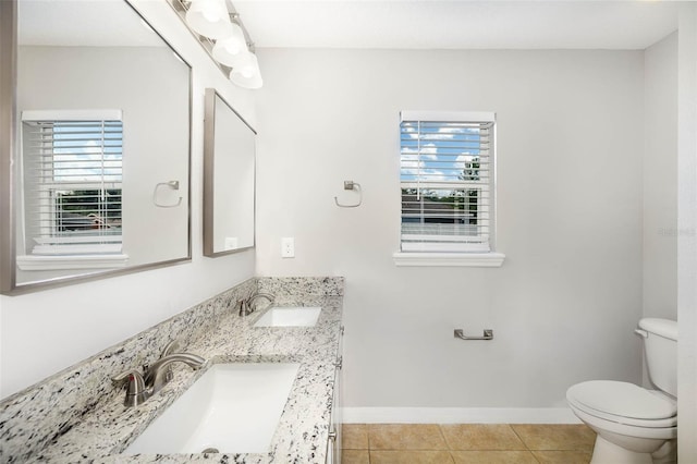 bathroom with tile patterned floors, vanity, a healthy amount of sunlight, and toilet