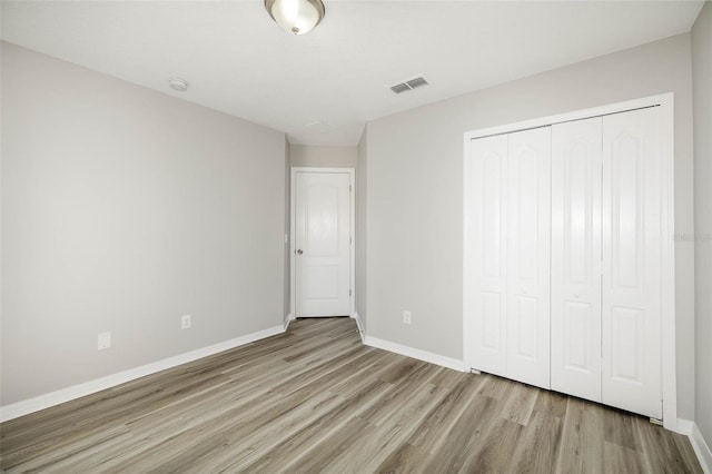 unfurnished bedroom featuring a closet and light hardwood / wood-style floors