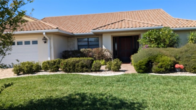 view of front of house featuring a garage and a front lawn