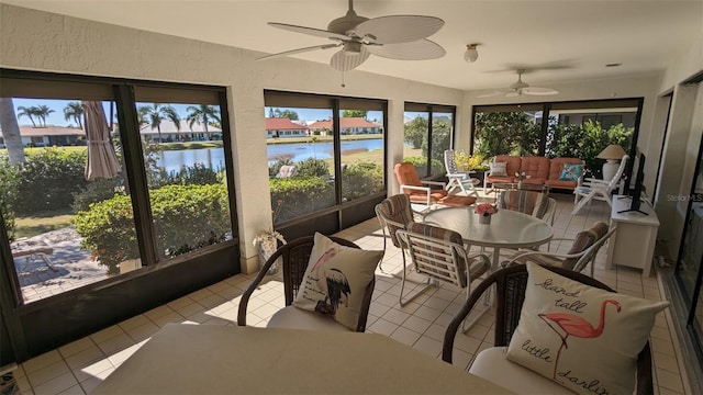 sunroom / solarium featuring a water view and ceiling fan