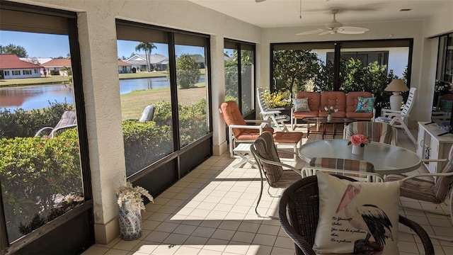 sunroom featuring a water view, ceiling fan, and plenty of natural light