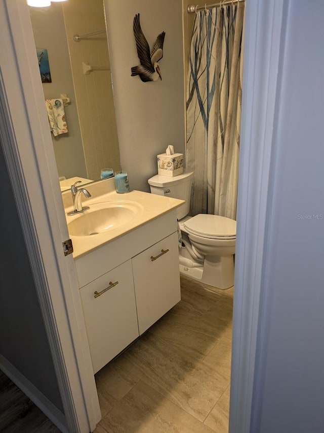 bathroom featuring a shower with curtain, vanity, and toilet