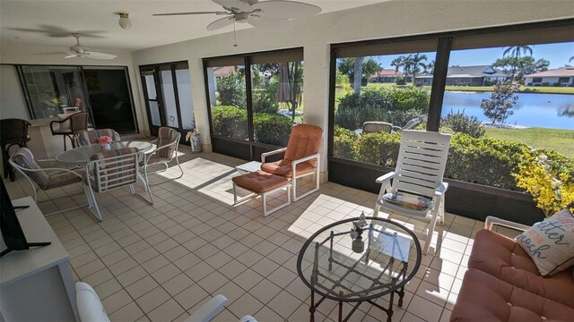 sunroom / solarium with a water view and ceiling fan