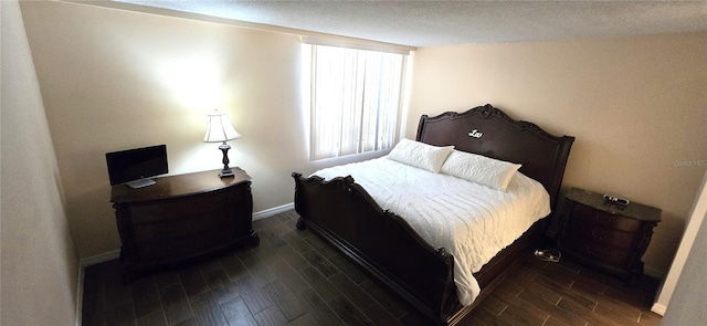 bedroom featuring dark hardwood / wood-style floors and a textured ceiling