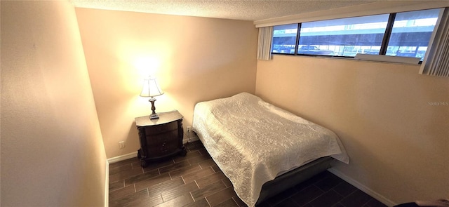 bedroom featuring a textured ceiling and dark wood-type flooring