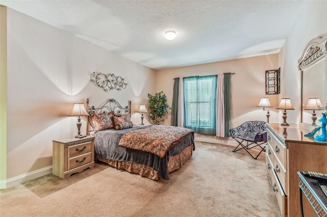 bedroom with a textured ceiling and light carpet