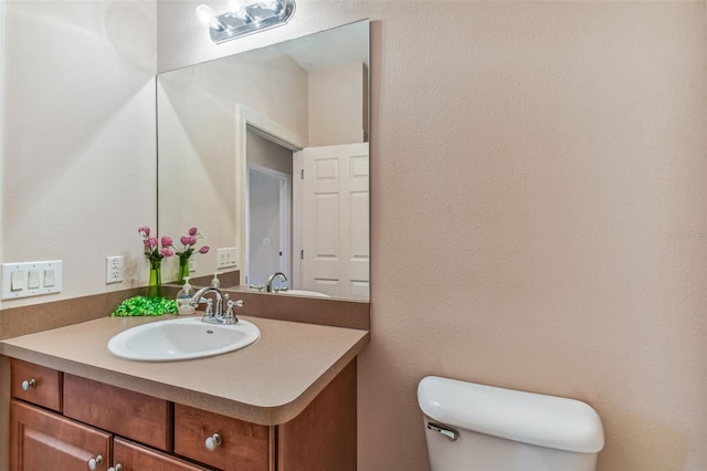 bathroom with toilet and large vanity