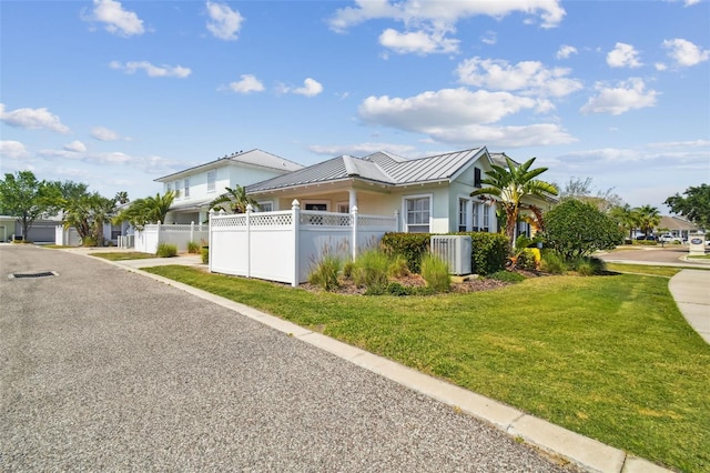 view of front of property featuring a front yard and central AC