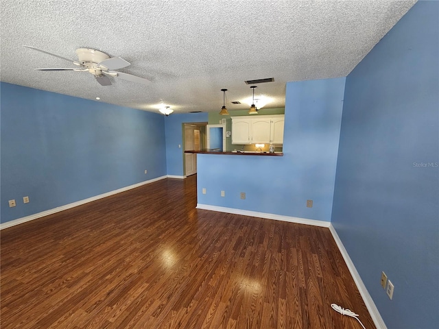 unfurnished living room with ceiling fan, a textured ceiling, and dark hardwood / wood-style flooring