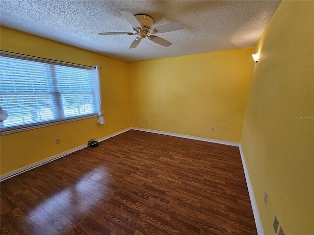 empty room featuring ceiling fan, a textured ceiling, and dark hardwood / wood-style flooring