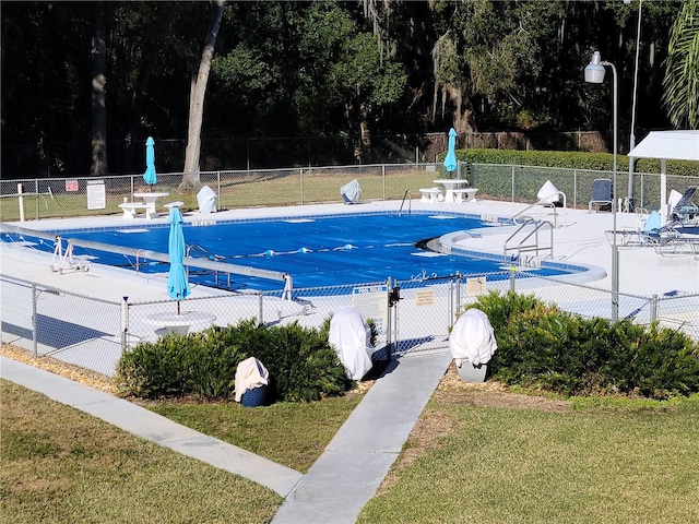 view of pool featuring a lawn and a patio