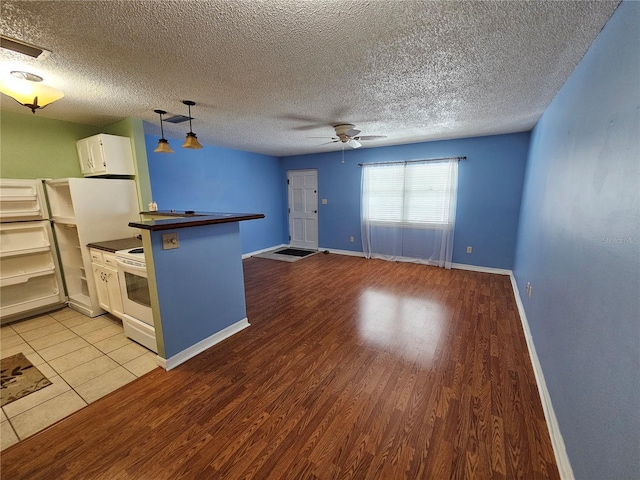 kitchen with light hardwood / wood-style floors, hanging light fixtures, ceiling fan, and white cabinets