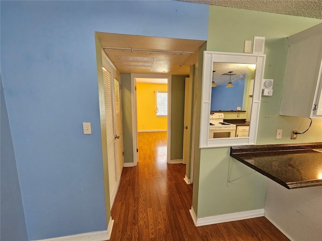 hall featuring a textured ceiling and dark hardwood / wood-style floors