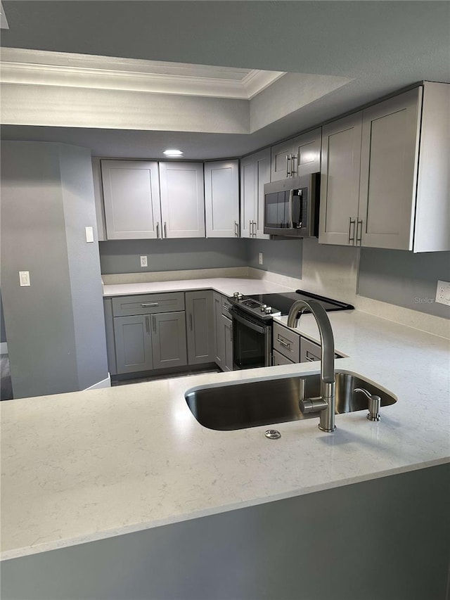 kitchen featuring ornamental molding, sink, light stone countertops, and gray cabinetry