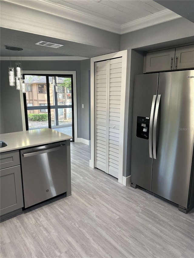 kitchen featuring gray cabinetry, stainless steel appliances, ornamental molding, and light hardwood / wood-style flooring