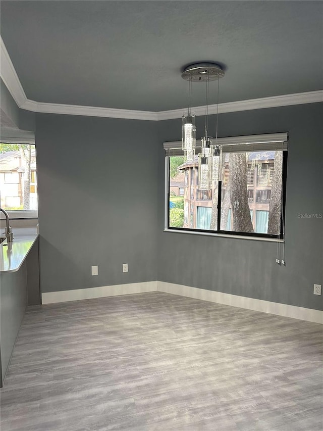 unfurnished dining area with ornamental molding and light hardwood / wood-style flooring