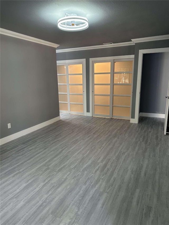 unfurnished living room with ornamental molding, a textured ceiling, and dark wood-type flooring