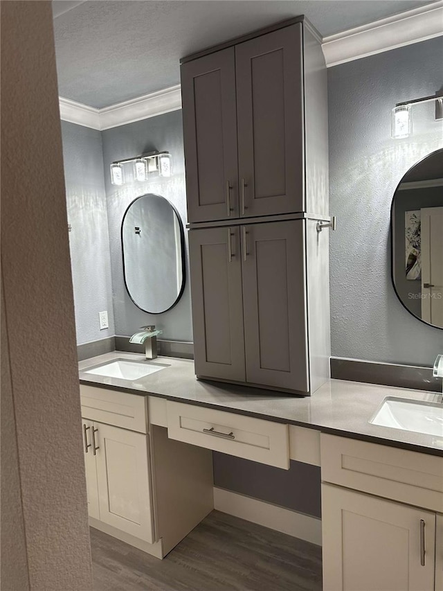 bathroom featuring vanity, crown molding, hardwood / wood-style floors, and a textured ceiling