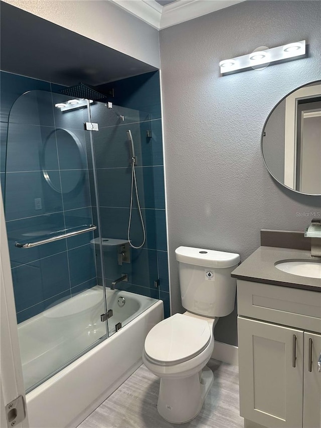 full bathroom with hardwood / wood-style floors, combined bath / shower with glass door, toilet, vanity, and crown molding