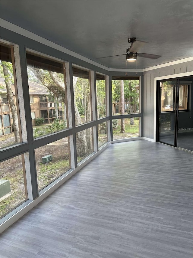 unfurnished sunroom featuring ceiling fan