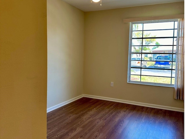 empty room featuring plenty of natural light and dark hardwood / wood-style flooring