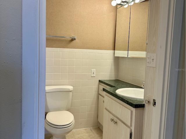 bathroom with tile floors, toilet, oversized vanity, and tile walls